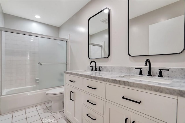 bathroom with tile patterned flooring, a sink, double vanity, and toilet