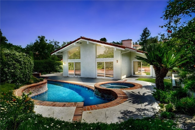 view of pool featuring a patio area and a pool with connected hot tub