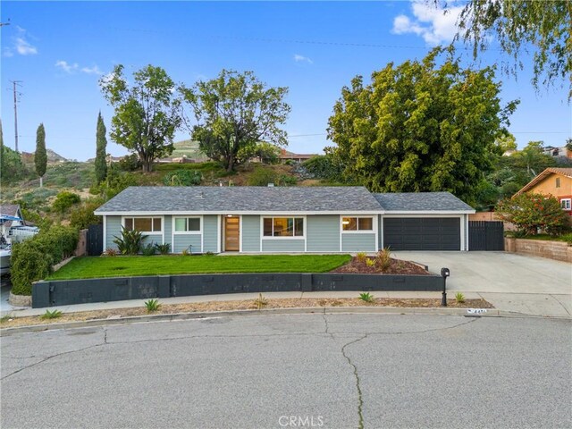 single story home with driveway, fence, a front yard, and a garage