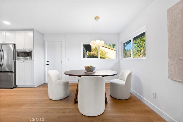 dining room featuring baseboards and light wood finished floors