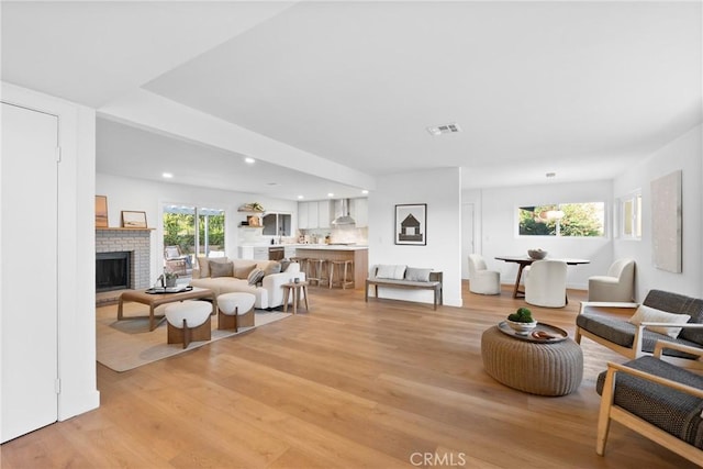 4421 Hempstead St, Simi Valley, CA 93063 - living area featuring light wood-style floors, healthy amount of natural light, a brick fireplace, and recessed lighting