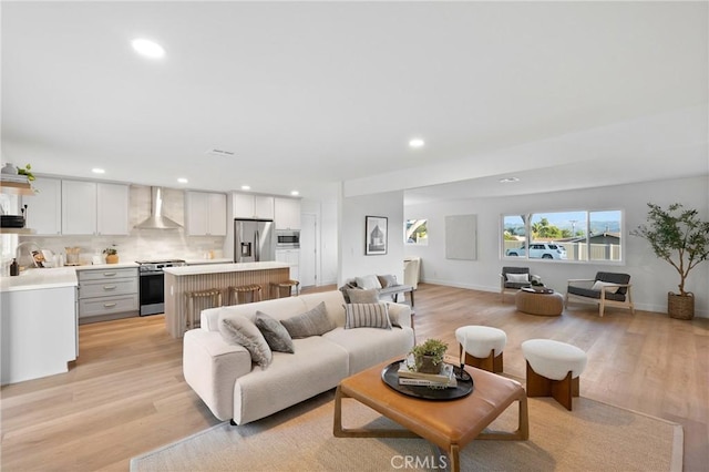 living room featuring light wood-style flooring, baseboards, and recessed lighting