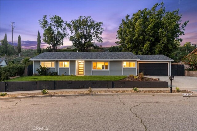 ranch-style house featuring a garage, a yard, and concrete driveway