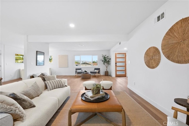 living area with baseboards, wood finished floors, visible vents, and recessed lighting