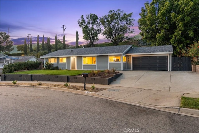 ranch-style home featuring a garage, driveway, and a front lawn