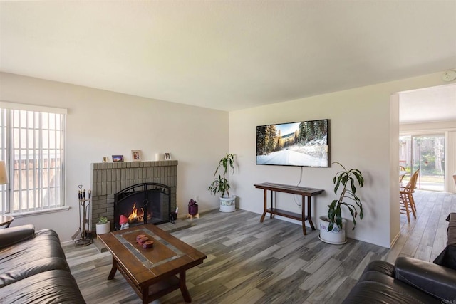 living room featuring a brick fireplace and wood finished floors