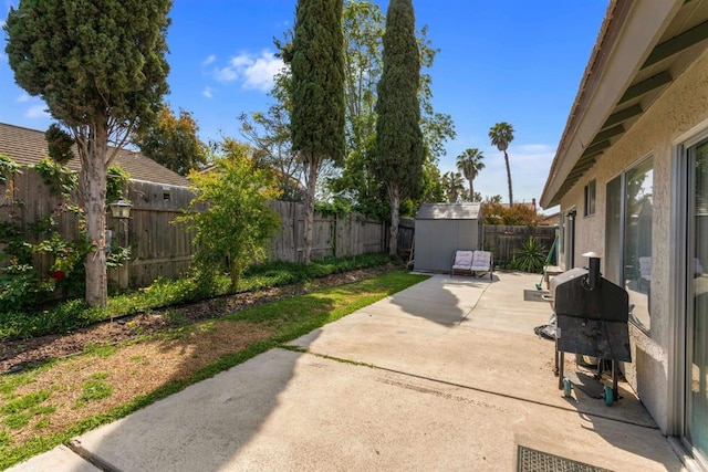 view of patio with a storage shed, grilling area, an outbuilding, and a fenced backyard