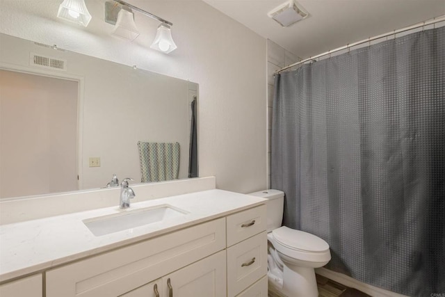 bathroom featuring vanity, a shower with curtain, toilet, and visible vents