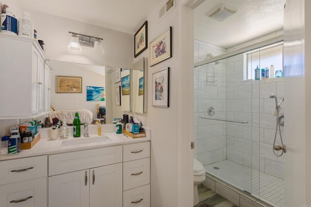 full bathroom with visible vents, a stall shower, toilet, and vanity