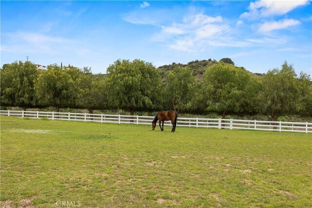 view of yard featuring fence and a rural view