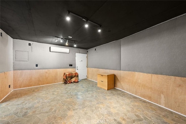 30052 Hunstock St, Castaic, CA 91384 - empty room featuring stone floors, an AC wall unit, track lighting, a wainscoted wall, and wood walls