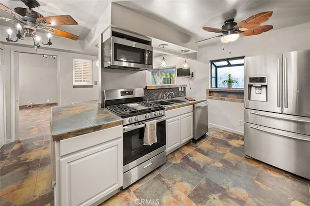 30052 Hunstock St, Castaic, CA 91384 - kitchen with appliances with stainless steel finishes, ceiling fan, a sink, and stone tile flooring