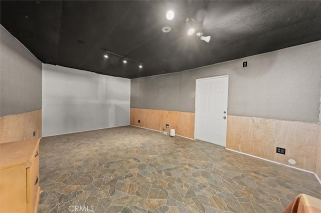 30052 Hunstock St, Castaic, CA 91384 - empty room featuring stone flooring, rail lighting, and a wainscoted wall