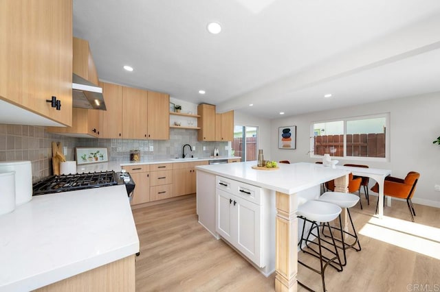 2263 Finch Ln, San Diego, CA 92123 - kitchen featuring light brown cabinets, exhaust hood, a breakfast bar, light wood-type flooring, and recessed lighting
