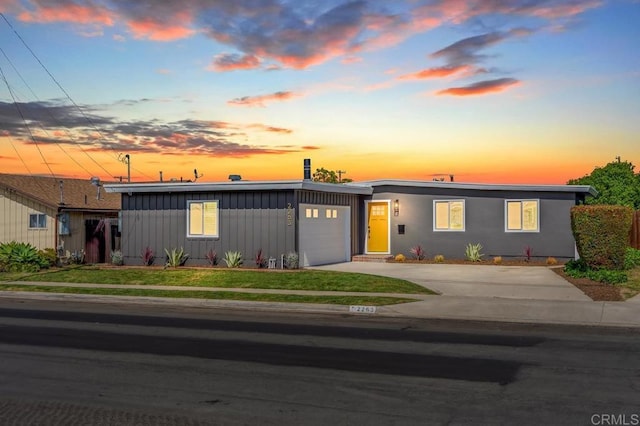 2263 Finch Ln, San Diego, CA 92123 - view of front of property with board and batten siding, a garage, concrete driveway, and a front lawn
