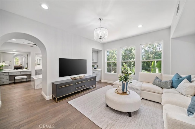 19 Ivanhoe, Irvine, CA 92602 - living area featuring arched walkways, wood finished floors, baseboards, and a notable chandelier