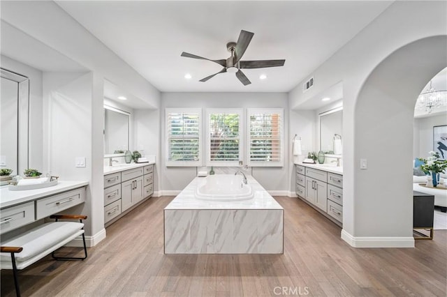 19 Ivanhoe, Irvine, CA 92602 - bathroom with two vanities, visible vents, a ceiling fan, wood finished floors, and a garden tub