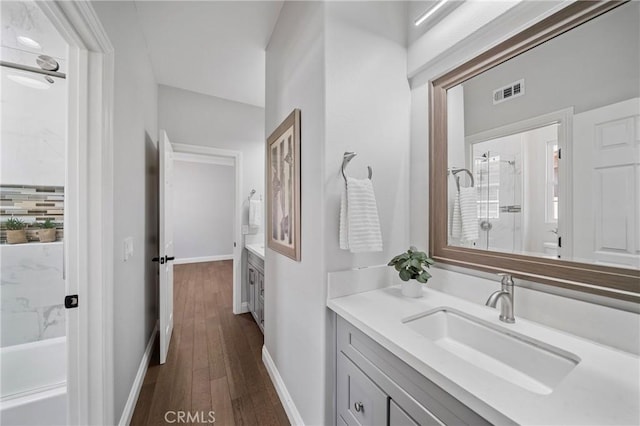 19 Ivanhoe, Irvine, CA 92602 - full bathroom featuring wood finished floors, vanity, a shower with shower door, baseboards, and visible vents