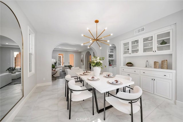 19 Ivanhoe, Irvine, CA 92602 - dining area featuring visible vents, an inviting chandelier, marble finish floor, and arched walkways