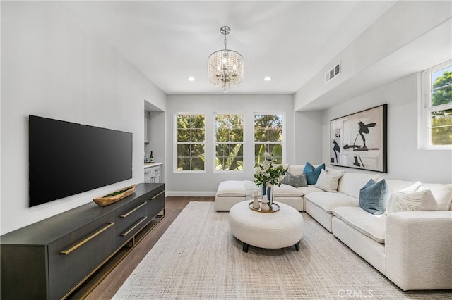 19 Ivanhoe, Irvine, CA 92602 - living area featuring dark wood-style flooring, baseboards, visible vents, recessed lighting, and a notable chandelier