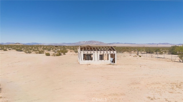 view of yard with a rural view, a desert view, and a mountain view