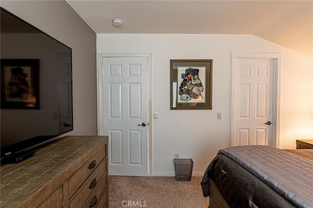 bedroom with carpet floors, baseboards, and vaulted ceiling