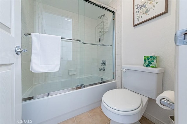full bathroom featuring baseboards, combined bath / shower with glass door, tile patterned floors, and toilet