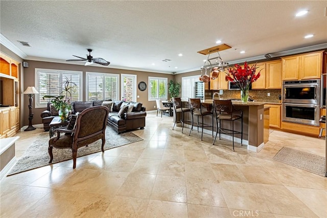 kitchen featuring crown molding, visible vents, double oven, open floor plan, and tasteful backsplash