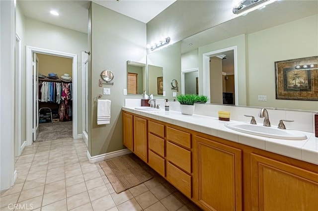 full bath featuring a sink, tile patterned flooring, and a stall shower