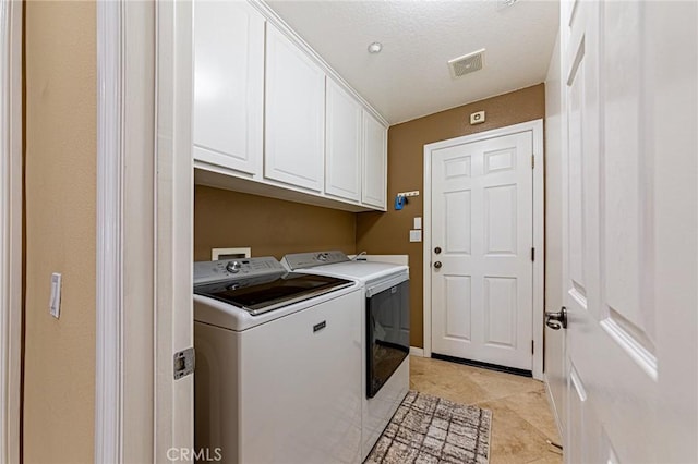 clothes washing area featuring cabinet space, light tile patterned flooring, visible vents, and washing machine and dryer