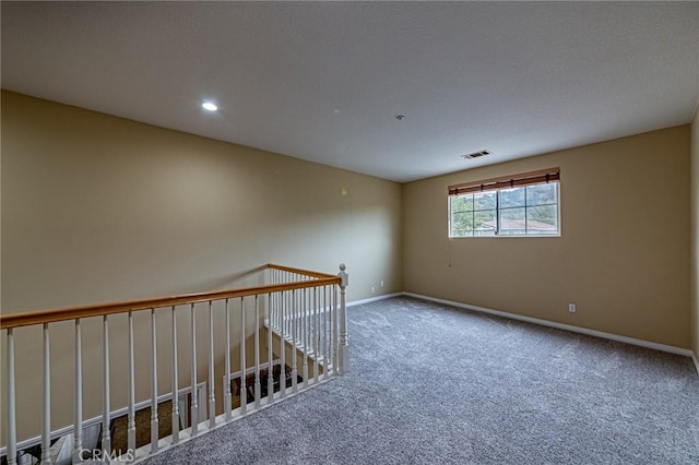 carpeted spare room featuring baseboards, recessed lighting, and visible vents