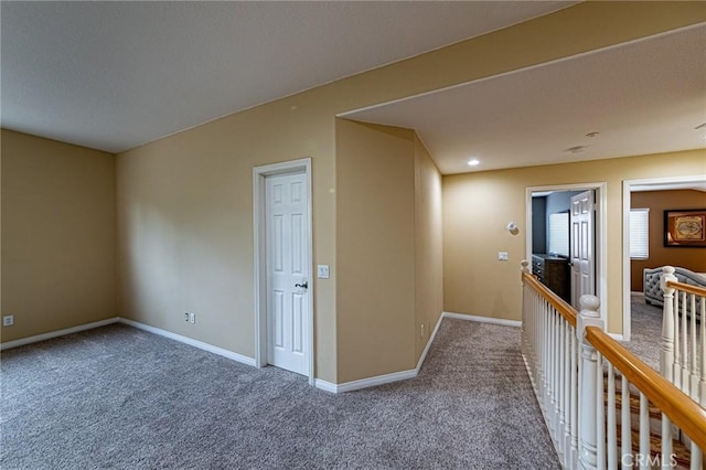 hall featuring baseboards and carpet