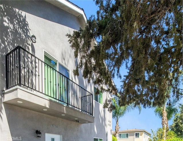 view of side of property with a balcony and stucco siding