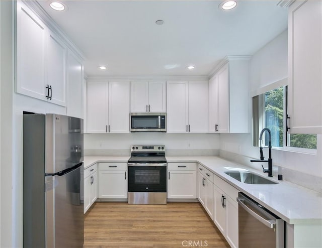 kitchen with recessed lighting, a sink, white cabinetry, and appliances with stainless steel finishes