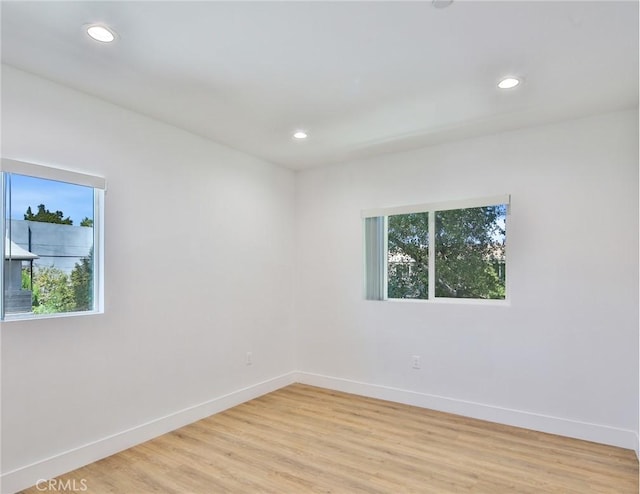 unfurnished room featuring recessed lighting, light wood-type flooring, and baseboards