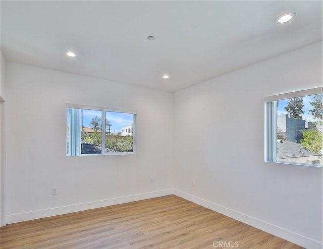 spare room featuring baseboards, recessed lighting, and light wood-style floors