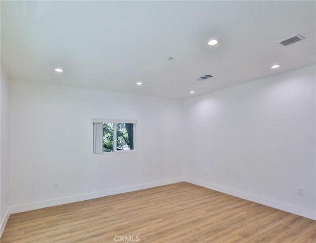 unfurnished room featuring light wood-type flooring, visible vents, and recessed lighting