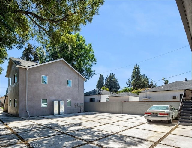 view of property exterior featuring stucco siding and fence