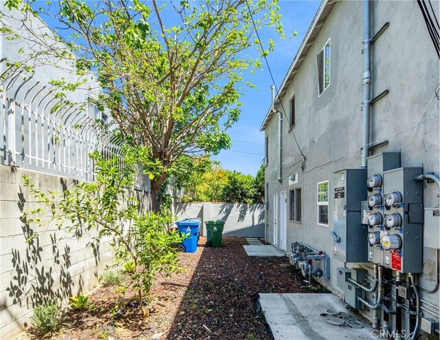 view of side of property with a fenced backyard and stucco siding