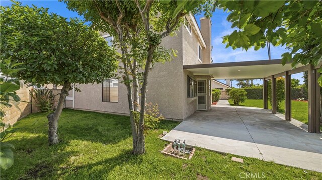view of property exterior with a patio, a fenced backyard, stucco siding, and a yard