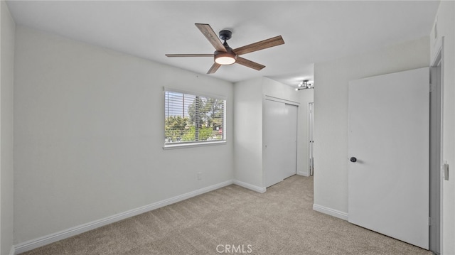 unfurnished bedroom with baseboards, a closet, light carpet, and ceiling fan