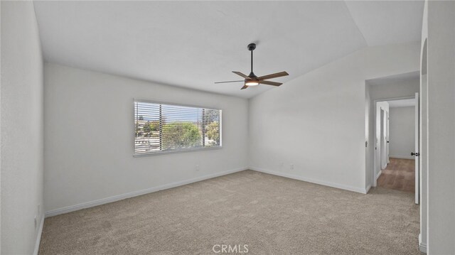 empty room featuring baseboards, a ceiling fan, carpet, and vaulted ceiling
