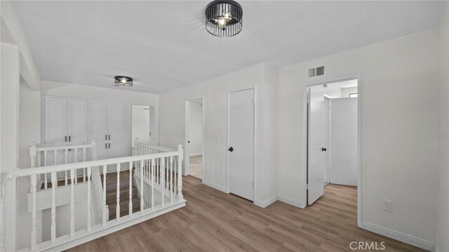 unfurnished bedroom with baseboards, wood finished floors, and visible vents