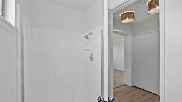 bathroom featuring wood finished floors and tiled shower