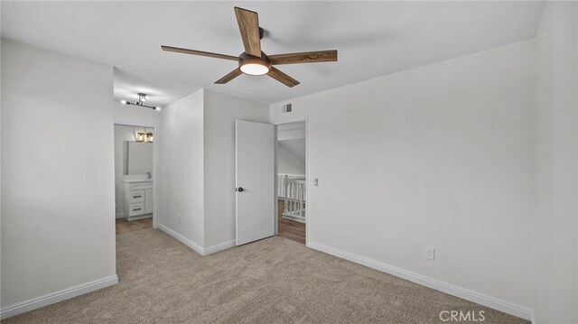 unfurnished bedroom with carpet flooring, ceiling fan, ensuite bath, baseboards, and visible vents