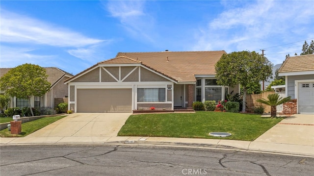 tudor house with a garage, a front yard, stucco siding, driveway, and a tile roof