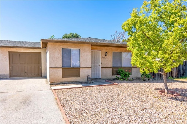 view of front of house with concrete driveway, fence, a garage, a shingled roof, and stucco siding