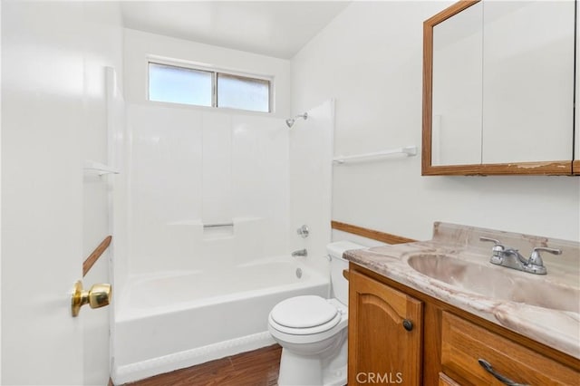 full bathroom featuring toilet, vanity, wood finished floors, and bathing tub / shower combination