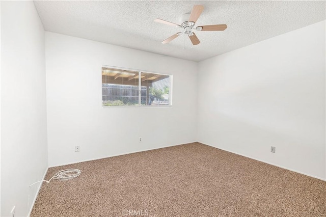 carpeted spare room with a textured ceiling and a ceiling fan