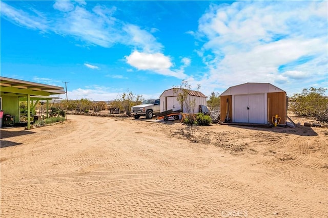 view of yard with an outdoor structure, a storage shed, and a garage